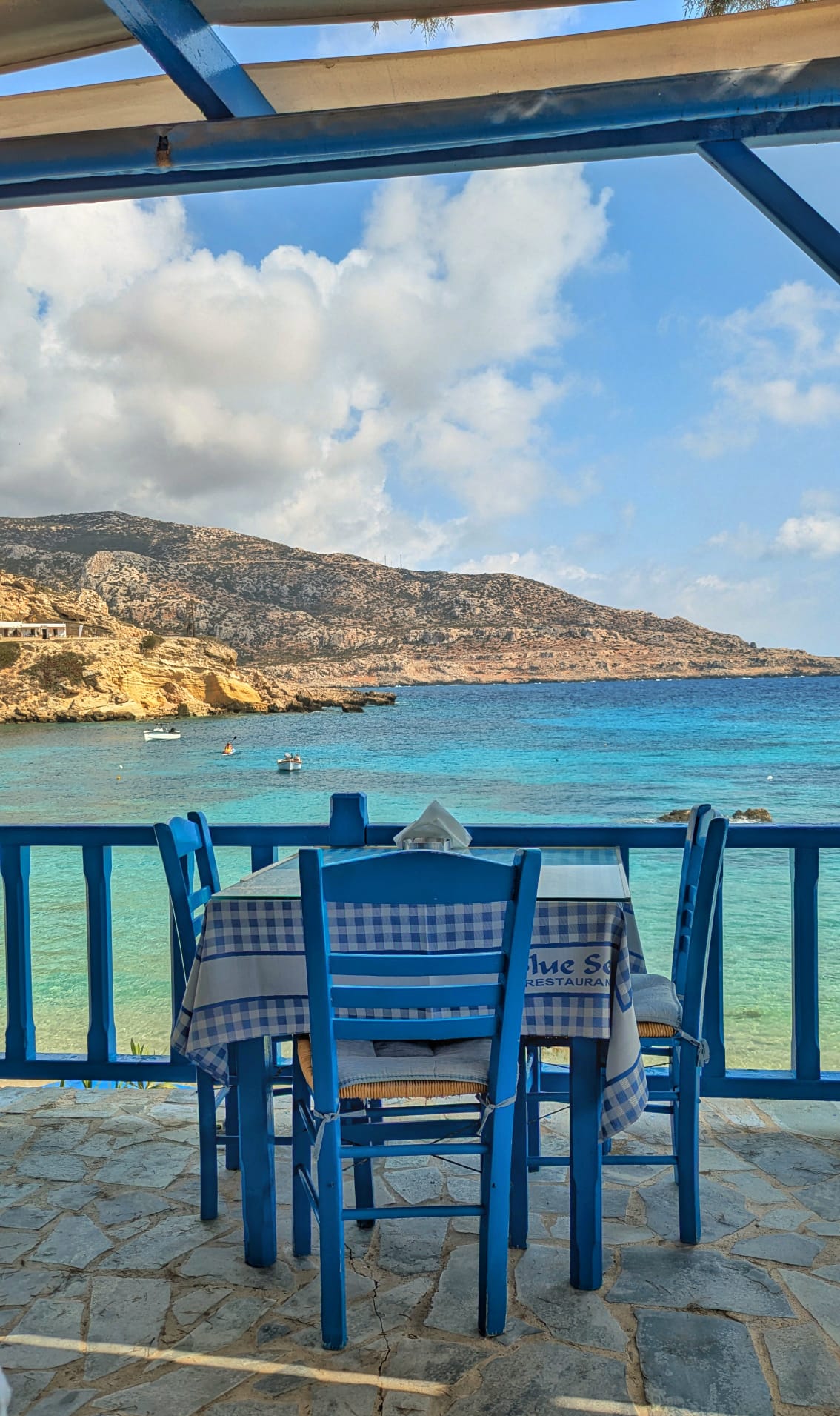 Tavolo azzurro su una terrazza con vista sul mare di Karpathos