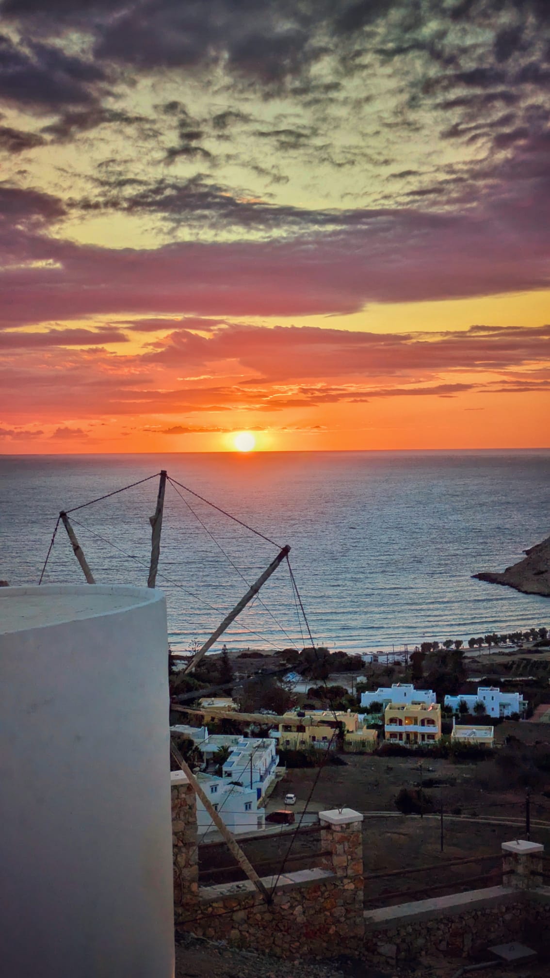 Tramonto su Karpathos con un mulino a vento in primo piano